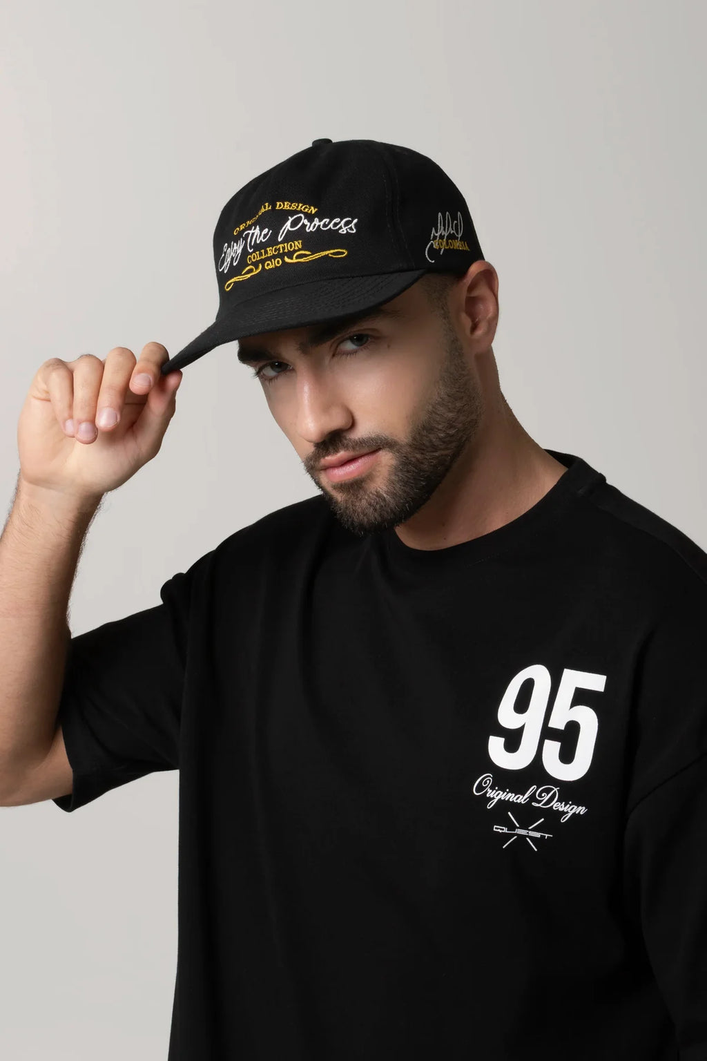 GORRA BEISBOLERA EN BLOQUES DE COLOR NEGRO CON BORDADO MARCA QUEST X JUAN FERNANDO QUINTERO